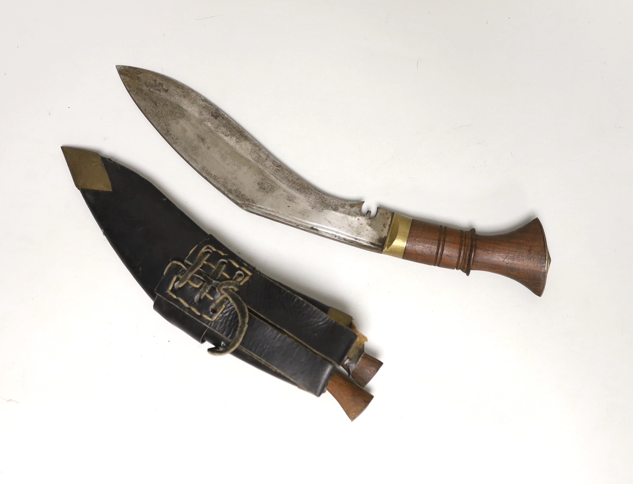 A kukri within white metal mounted sheath, blade 27cm, and three others, one with bone handle